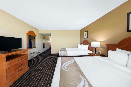 a hotel room with two beds and a flat screen tv at Quality Inn & Suites Sevierville - Pigeon Forge in Sevierville