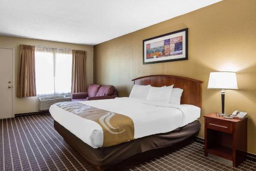 a hotel room with a large bed and a chair at Quality Inn & Suites Sevierville - Pigeon Forge in Sevierville