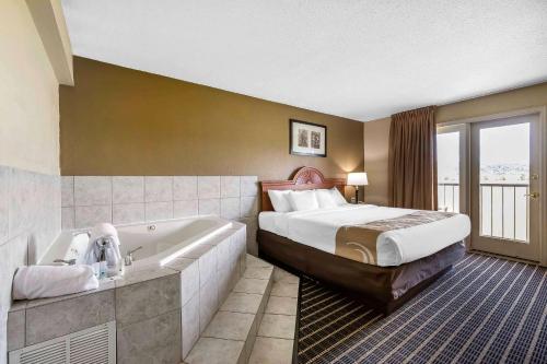 a hotel room with a bed and a bath tub at Quality Inn & Suites Sevierville - Pigeon Forge in Sevierville