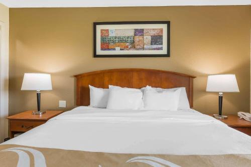 a bed in a hotel room with two lamps at Quality Inn & Suites Sevierville - Pigeon Forge in Sevierville