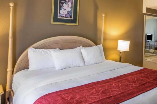 a bed with white pillows and a red blanket at Quality Suites Morristown West in Morristown