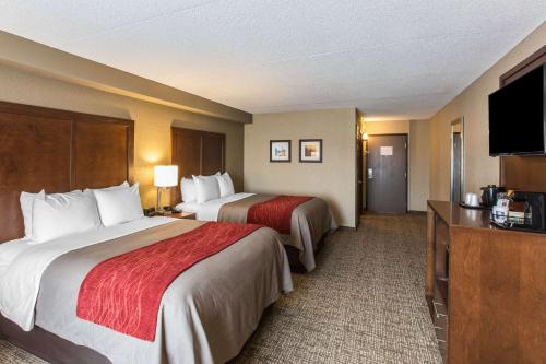 a hotel room with two beds and a flat screen tv at Comfort Inn & Suites Knoxville West in Knoxville