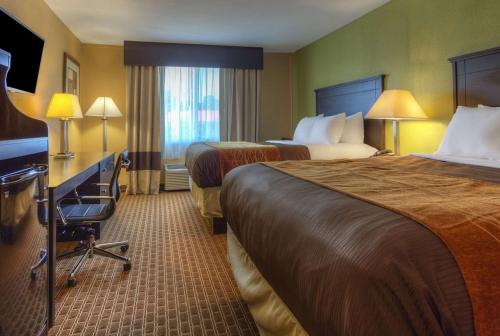 a hotel room with two beds and a desk at Quality Inn & Suites in Chattanooga