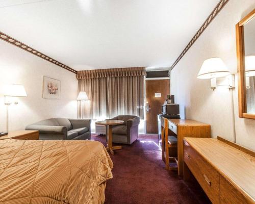 a hotel room with a bed and a living room at Rodeway Inn in Sweetwater