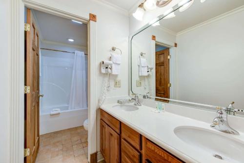 a bathroom with two sinks and a large mirror at Quality Inn Creekside - Downtown Gatlinburg in Gatlinburg