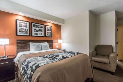 a hotel room with a bed and a chair at Sleep Inn in Nashville