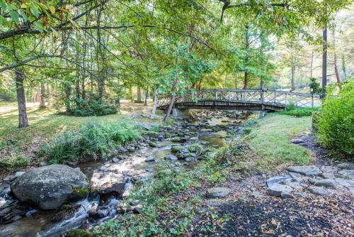 a bridge over a river with rocks and trees at Quality Inn Creekside - Downtown Gatlinburg in Gatlinburg