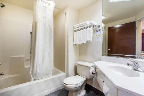 a bathroom with a toilet and a sink and a tub at Quality Inn Hixson-Chattanooga in Hixson