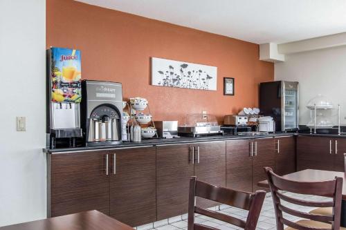 a kitchen with brown cabinets and a table with chairs at Sleep Inn Nashville near Percy Priest Lake in Nashville