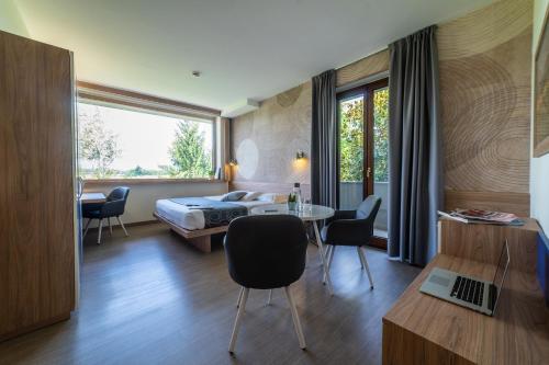 a bedroom with a bed and a table and chairs at Hotel Gardenia in Romano Canavese