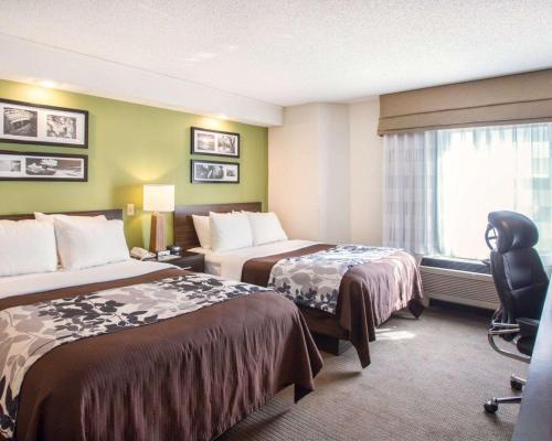 Sleep Inn Nashville Downtown Opryland Area في ناشفيل: غرفة فندقية بسريرين ونافذة