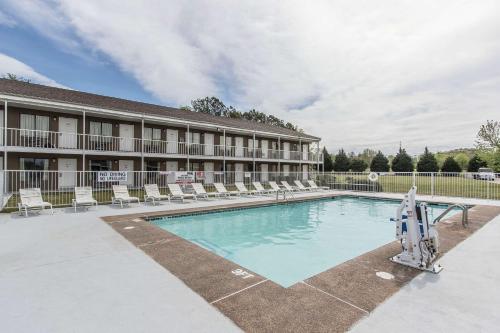 a pool in front of a hotel with chairs at Rodeway Inn Jackson Northwest in Jackson