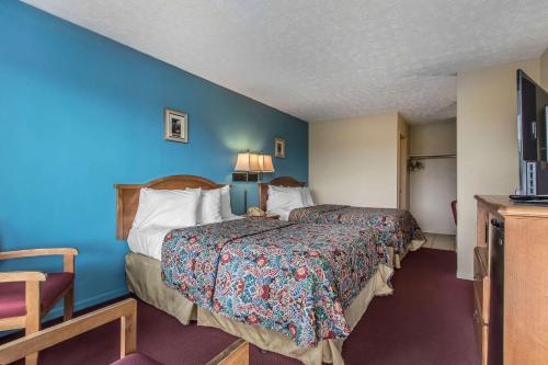 a hotel room with two beds and a blue wall at Rodeway Inn Jackson Northwest in Jackson