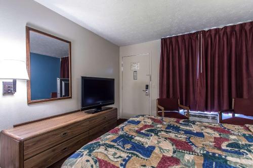 a hotel room with a bed and a flat screen tv at Rodeway Inn Jackson Northwest in Jackson
