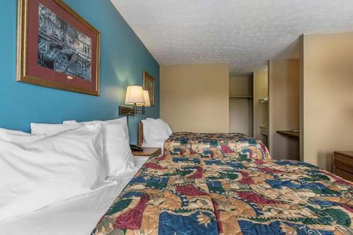 a hotel room with a bed with a quilt on it at Rodeway Inn Jackson Northwest in Jackson