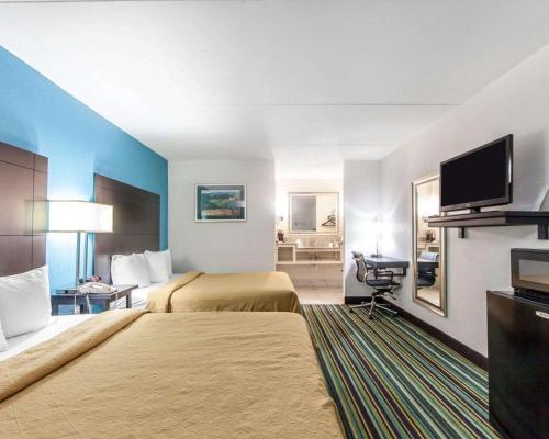 a hotel room with two beds and a flat screen tv at Quality Inn & Suites in Jasper