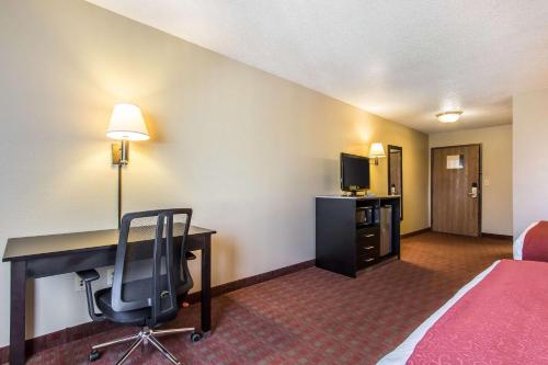 a hotel room with a desk and a chair at Quality Inn & Suites in La Vergne