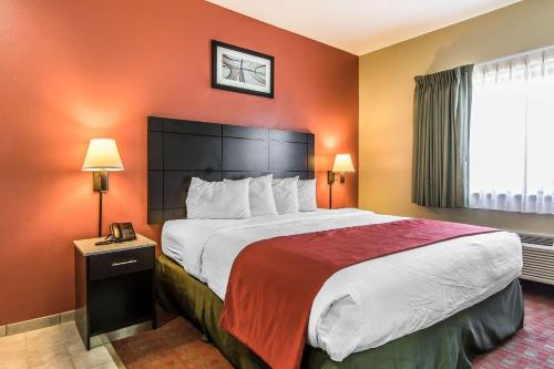 a hotel room with a large bed with orange walls at Quality Inn & Suites in La Vergne