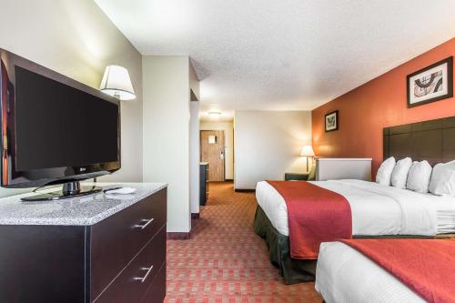 a hotel room with two beds and a flat screen tv at Quality Inn & Suites in La Vergne