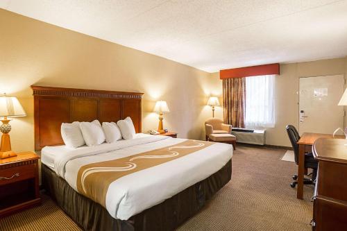 Hurricane MillsにあるQuality Inn Hurricane Millsの大きなベッドとデスクが備わるホテルルームです。