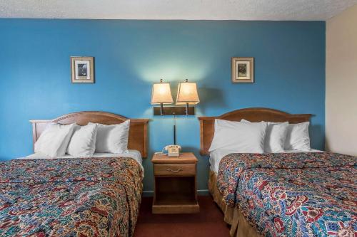 two beds in a hotel room with blue walls at Rodeway Inn Jackson Northwest in Jackson