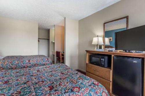 a hotel room with a bed and a flat screen tv at Rodeway Inn Jackson Northwest in Jackson