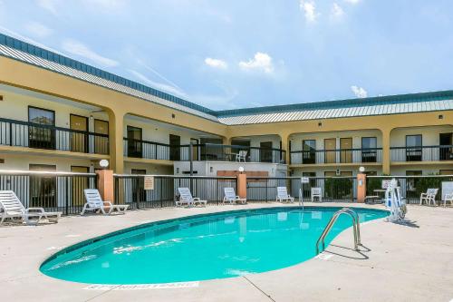 a pool in front of a hotel with chairs and a building at Rodeway Inn Knoxville East in Knoxville