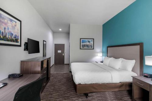 a hotel room with a bed and a desk at Clarion Inn & Suites DFW North in Irving