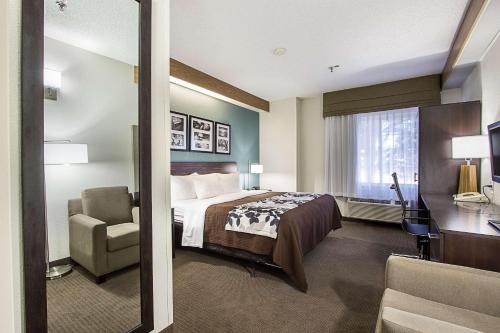Habitación de hotel con cama y silla en Sleep Inn University, en El Paso