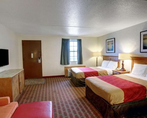 a hotel room with two beds and a television at Rodeway Inn New Braunfels - San Antonio Area in New Braunfels