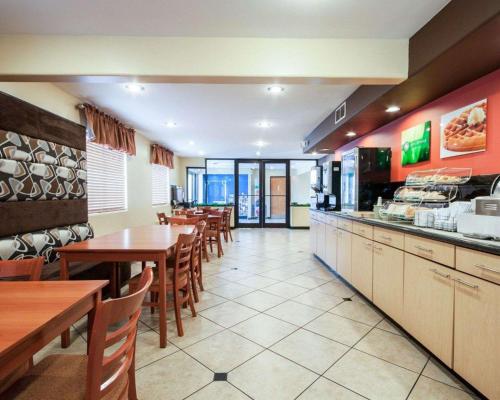 a restaurant with tables and chairs and a kitchen at Quality Inn Airport East in El Paso