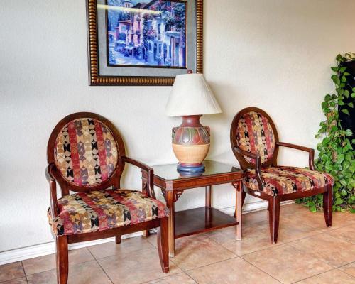 two chairs and a table with a lamp on it at Rodeway Inn New Braunfels - San Antonio Area in New Braunfels