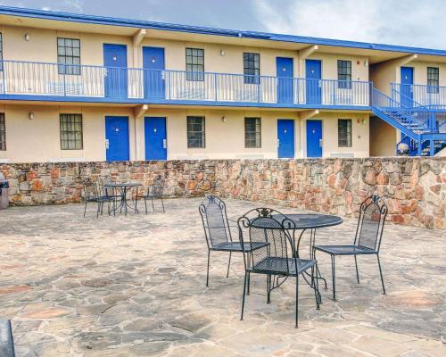 a patio area with chairs, tables, and a building at Rodeway Inn New Braunfels in New Braunfels