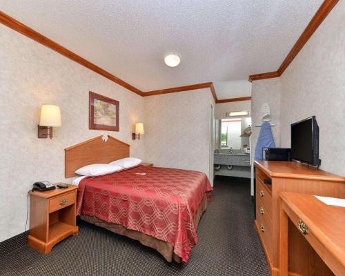 ein Hotelzimmer mit einem Bett und einem Flachbild-TV in der Unterkunft Econo Lodge in Killeen