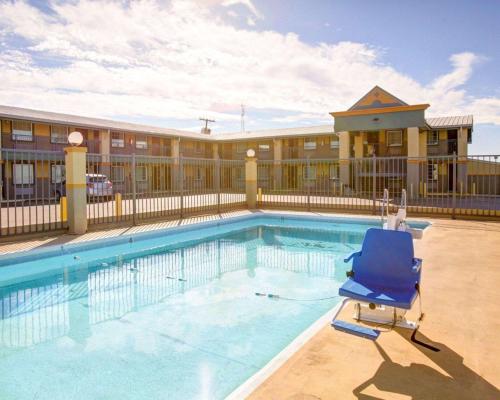 una piscina con una silla azul frente a un hotel en Econo Lodge Temple, en Temple