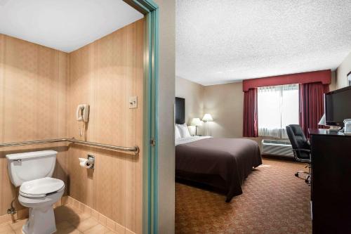 a hotel room with a bed and a toilet at Quality Inn Dumas in Dumas