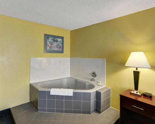 een groot bad in een kamer met een lamp bij Quality Inn & Suites Grand Prairie South in Grand Prairie