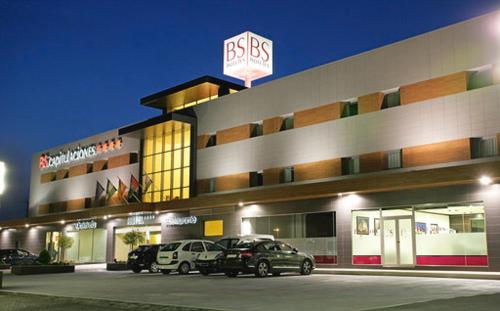 a large building with cars parked in front of it at BS Capitulaciones in Santa Fe