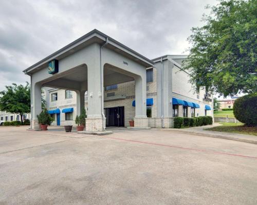 an empty parking lot in front of a building at Quality Inn & Suites Grand Prairie South in Grand Prairie