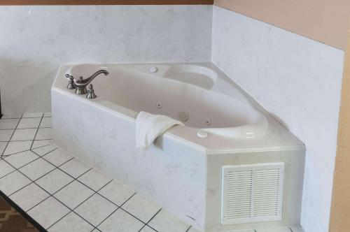 a white bath tub in a bathroom with a towel at Comfort Inn North Conroe in Conroe