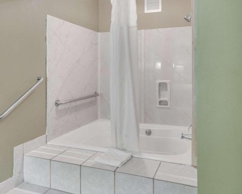 uma casa de banho com uma banheira e um chuveiro com uma cortina de chuveiro em Quality Inn Mt. Pleasant em Mount Pleasant