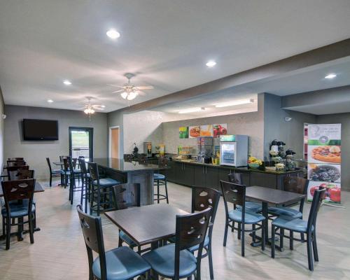 a restaurant with tables and chairs and a bar at Quality Inn & Suites Grand Prairie South in Grand Prairie