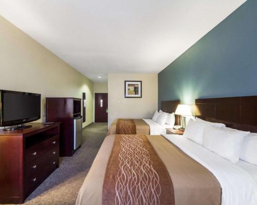 a hotel room with two beds and a flat screen tv at Quality Inn Ingleside - Corpus Christi in Ingleside
