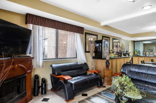 a living room with two leather chairs and a television at Quality Inn Dumas in Dumas