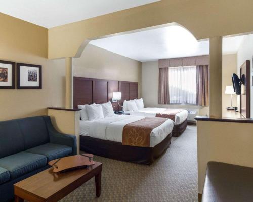 a hotel room with two beds and a couch at Quality Suites Midland North Loop 250 in Midland