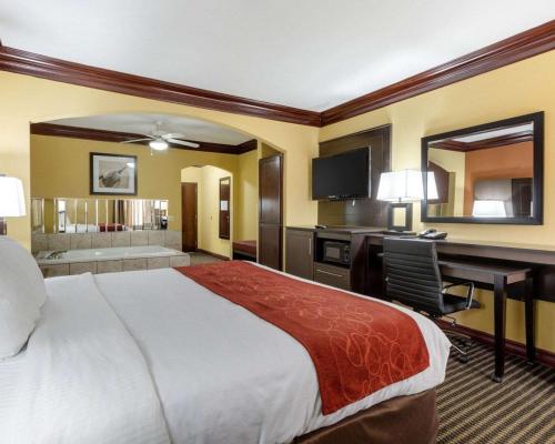 a hotel room with a large bed and a desk at Comfort Suites Lake Jackson Clute in Lake Jackson