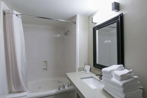 a white bathroom with a sink and a mirror at Comfort Suites Austin NW Lakeline in Austin