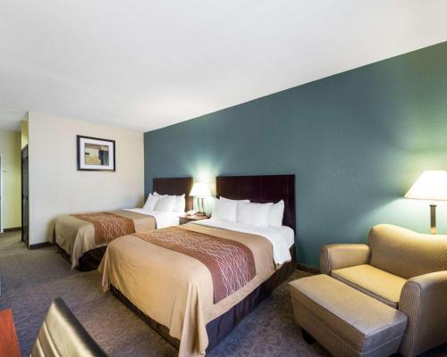 a hotel room with two beds and a chair at Quality Inn Ingleside - Corpus Christi in Ingleside