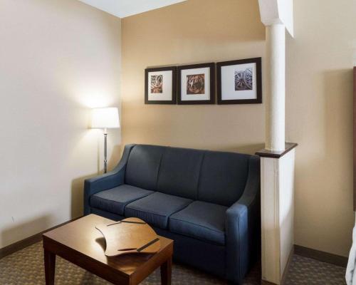 a living room with a blue couch and a table at Quality Suites Midland North Loop 250 in Midland
