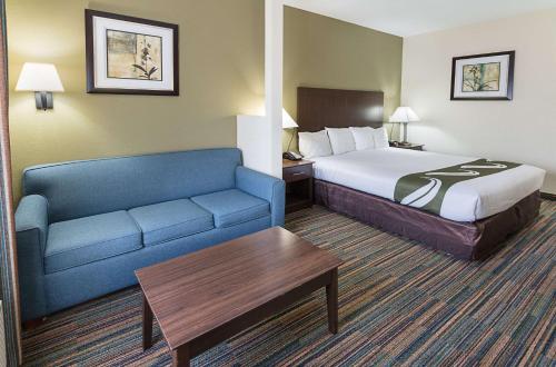 a hotel room with a bed and a couch at Quality Suites in Temple